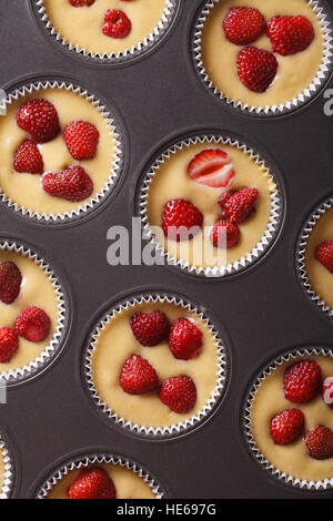 raw strawberry muffins in baking dish closeup. vertical top view Stock Photo