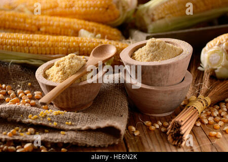 corn flour in wooden bowl with the cobs around Stock Photo