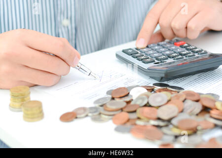 Tax calculation or new loan agreement with hand calculator and coins Stock Photo