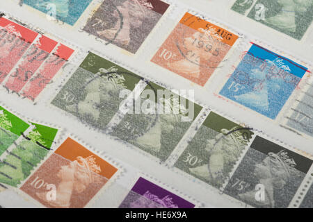 some old UK postage stamps in a collection album Stock Photo