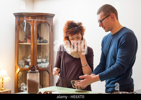 Young men and women are preparing chocolate truffles in a shop Stock Photo