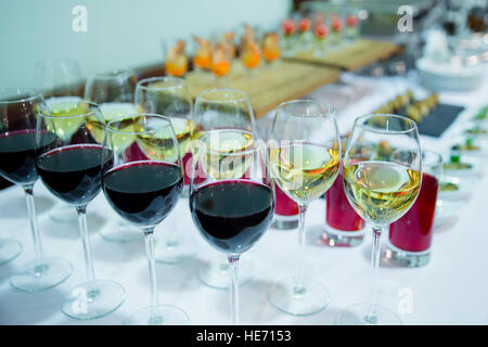Glasses with white and red wine with on white table appetizer Stock Photo