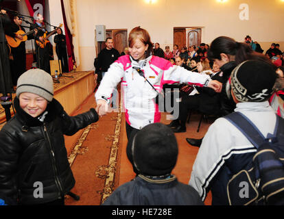 Staff Sgt. Carolyn Viss, 376th Air Expeditionary Wing Public Affairs journalist dances with children from the audience during a performance by the U.S. Air Forces Central band 'Celtic Aire' in Tamga Village, Kyrgyzstan, Jan. 29. Senior Airman Nichelle Anderson Stock Photo