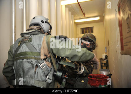 A member of the 51st Operations Support Squadron aircrew flight equipment section uses M-295 pads to 'decontaminate' the flight suit of Capt. William Yoakley, 25th Fighter Squadron A-10 Thunderbolt II pilot, during Operational Readiness Exercise Beverly Midnight 14-01 at Osan Air Base, Republic of Korea, Jan. 15, 2014. Yoakley was one of several pilots who participated in a training scenario to practice donning chemical, biological, radiological and nuclear threat protection flight gear. Airman 1st Class Ashley J. Thum) Stock Photo