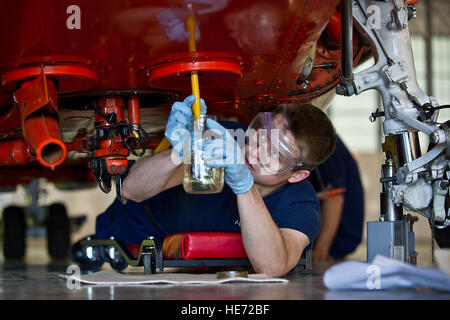 U.S. Coast Guard Airman Lucas Dellams takes fuels sample from an HH-65B Dolphin helicopter during a routine maintenance inspection at Coast Guard Air Station Kodiak, Alaska, June 26, 2012.  Tech. Sgt. Michael R. Holworth, U.S. Air Force Stock Photo