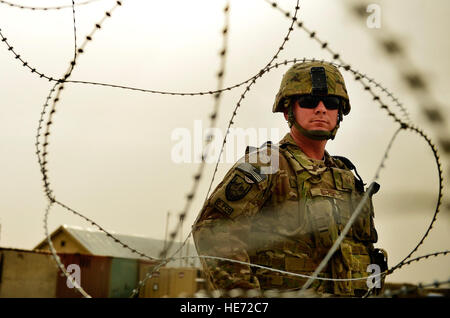 U.S. Air Force Staff Sgt. Derek Butori, 4th Infantry Division, ammunitions adviser to the Afghan National Army, observes an ANA compound, Kandahar province, Afghanistan, March 13, 2014. There are currently five Joint Expeditionary Tasked Airmen assigned to the 4th Infantry Division sharing the responsibility for training ANA southern region soldiers to become completely self sustaining with weapons and vehicle maintenance. Butori, deployed from the 31st Munitions Squadron, Aviano Air Base, Italy, is a Dillon, Mont., native, who advises the ANA on use of more than $30 million in ammunition, ANA Stock Photo