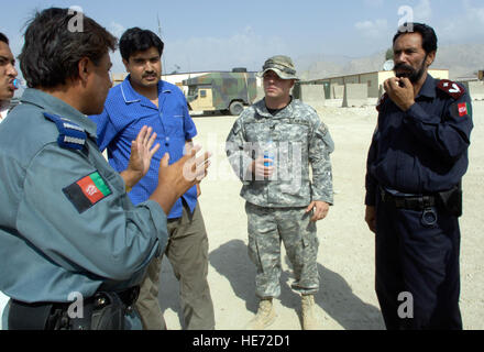U.S. Air Force security forces Staff Sgt. Daniel Smith (second from right) listens to a question on riot control procedures from Afghan National Police (ANP) Capt. Muhammad Ajan (left) during a break in a training session for Afghan National Auxiliary Police (ANAP) trainees on Thursday, Sept. 6, 2007. Sergeant Smith is deployed form Malmstrom Air Force Base, Montana. He is assigned to the Laghman Provincial Reconstruction Team (PRT) police technical advisory team (PTAT). The trainees are attending a two-week ANAP sustainment course being held on forward operating base (FOB) Mehtar Lam in Afgha Stock Photo
