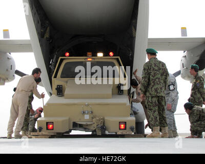 KABUL, Afghanistan – Afghan National Army Air Corps soldiers and their U.S mentors help guide a 6,000 pound “tug” truck into the C-27 on Jun 8, 2010. This is the largest load both coordinated and loaded exclusively by the Afghan Air Corps.  ( Tech. Sgt. Mike Tateishi/) Stock Photo