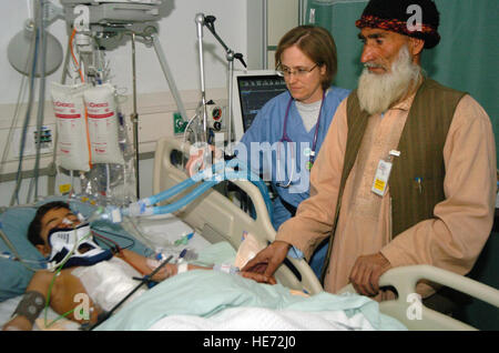 Amin Gul, a 10-year-old Afghan boy who was struck by a vehicle Jan. 30 between Kabul and Bagram Airfield, is still in critical condition following extensive surgery to save his life. Amin is accompanied by his grandfather Said Faqeer and Air Force Maj. Nicole Thomas, Crain Joint Theater Hospital pediatrician. Senior Airman James Bolinger) Stock Photo