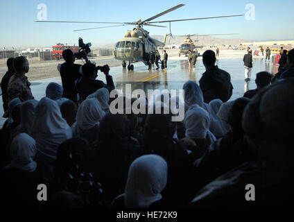 Afghan children watch as two Mi-17 helicopters land and passengers exit the aircraft in front of the Afghanistan National Army Air Corps hangar Dec. 31, 2009. : Staff Sgt. Angelique N. Smythe) Stock Photo