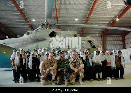 Col. Mark Nichols, 438th Air Expeditionary Training Group commander, Maj. Gen. Abduhl Raziq Sherzai, commander of the ANAAC, and Air Commodore Malcolm Brecht, commander of Kandahar Airfield, take photos with Afghan students in the Afghanistan National Army Air Corps hangar on Kandahar Airfield. Approximately 250 children from local schools in Kandahar City visited the ANAAC Dec. 31, 2009. : Staff Sgt. Angelique N. Smythe) Stock Photo