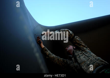 AC-130U gunship Crew Chief A1C James Marsh from the 4th Aircraft Maintenance Squadron, attaches a panel back on to the plane during routine maintenance on January 28,2011 at Hurlburt Field, Fla. The AC-130U 'Spooky' gunship is the primary weapon of Air Force Special Operations Command. Its primary missions are close air support, air interdiction and armed reconnaissance. The U model is an upgraded version of the H and is equipped with side firing, trainable 25mm, 40mm, and 105mm guns. ( Master Sgt. Jeremy T. Lock) (Released) Stock Photo