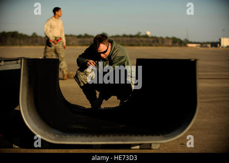 AC-130U gunship Crew Chief SrA. Christopher Gibson from the 4th Aircraft Maintenance Squadron, prepares to attach a panel back on to the plane during routine maintenance on January 28,2011 at Hurlburt Field, Fla. The AC-130U 'Spooky' gunship is the primary weapon of Air Force Special Operations Command. Its primary missions are close air support, air interdiction and armed reconnaissance. The U model is an upgraded version of the H and is equipped with side firing, trainable 25mm, 40mm, and 105mm guns. ( Master Sgt. Jeremy T. Lock) (Released) Stock Photo