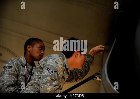 AC-130U gunship Crew Chief A1C. Felipe Romero and A1C. Jason Powell from the 4th Aircraft Maintenance Squadron, attach a panel back on to the plane during routine maintenance on January 28,2011 at Hurlburt Field, Fla. The AC-130U 'Spooky' gunship is the primary weapon of Air Force Special Operations Command. Its primary missions are close air support, air interdiction and armed reconnaissance. The U model is an upgraded version of the H and is equipped with side firing, trainable 25mm, 40mm, and 105mm guns. ( Master Sgt. Jeremy T. Lock) (Released) Stock Photo