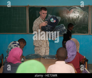 U.S. Marine Lance Cpl. Kevin Howard, Combined Joint Task Force - Horn of Africa radio transmission operator, passes out backpacks to children at Ali Sabieh Primary School 3 in Ali Sabieh, Djibouti, Jan. 16. The team delivered more than 5,000 backpacks to students in 16 schools in the Ali Sabieh area. Stock Photo