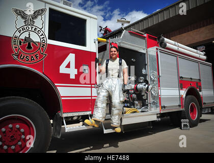 U.S. Air Force Staff Sgt. Estrella Martinez, 27th Special Operations Civil Engineer Squadron fire protection, hangs from the side of a fire engine outside the Fire Department at Cannon Air Force Base, N.M., May 21, 2013. Martinez is an exemplary Air Commando who was recently presented with the John L. Levitow Traveling Trophy, the most distinguished honor an Airman Leadership School graduate can receive from instructors through peer nomination. Senior Airman Alexxis Pons Abascal) Stock Photo