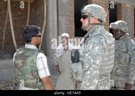 Provincial Reconstruction Team members use an interpreter to discuss construction progress at Nilay Boys and Girls School in Kohi Safi, Bagram Airfield, Afghanistan, on August 6. The team evaluates construction projects and provides oversight for quality control and project management. Stock Photo
