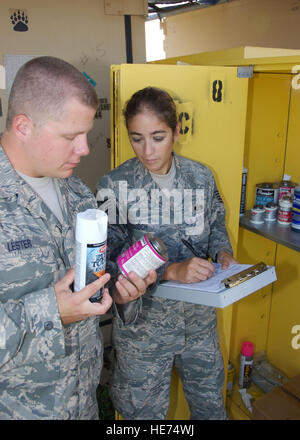 Air Force Senior Airman Anthony Lester, deployed with the 474th Expeditionary Civil Engineering Squadron in support of Joint Task Force Guantanamo, assists Air Force Tech Sgt. Jeanette Gooch during an inspection of a hazardous waste storage locker at U.S. Naval Station Guantanamo Bay, July 21. Gooch works primarily with chemical and biological agents in support of JTF Guantanamo. JTF Guantanamo conducts safe, humane, legal and transparent care and custody of detainees, including those convicted by military commission and those ordered released by a court. The JTF conducts intelligence collecti Stock Photo