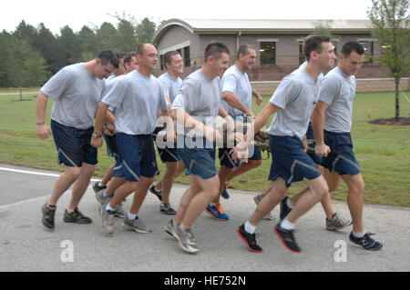 Airmen from 20th Civil Engineering Squadron, Explosive Ordinance Disposal  run together carrying a dummy during the 5K Poker Run at Shaw Air Force Base, S.C., Aug. 10, 2012. They trained carrying the dummy to promote team work and practiced the concept “never leave an Airman behind.” To support that belief, they carried the dummy through the entire 3 ½ mile race.  Airman 1st Class Krystal M. Jeffers Stock Photo