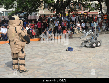 Senior Airman Corey Mcenery, 502nd Civil Engineer Squadron Explosive Ordnance Disposal technician at Joint Base San Antonio-Lackland, demonstrates the uses of a bomb suit and robot as part of bomb disposal procedures during Air Force at the Alamo events in conjunction with Fiesta San Antonio April 20.  The suit weighs about 80 pounds and protects Airmen from explosives at an arm’s length, or roughly three feet. The robot is used to keep Airmen safe at a greater distance and can be used to inspect and remove a suspicious package.   Melissa Peterson/released) Stock Photo