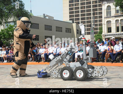 Senior Airman Corey Mcenery, 502nd Civil Engineer Squadron Explosive Ordnance Disposal technician at Joint Base San Antonio-Lackland, demonstrates the uses of a bomb suit and robot as part of bomb disposal procedures during Air Force at the Alamo events in conjunction with Fiesta San Antonio April 20. The suit weighs about 80 pounds and protects Airmen from explosives at an arm’s length, or roughly 3 feet. The robot is used to keep Airmen safe at a greater distance and can be used to inspect and remove a suspicious package.  Melissa Peterson/released) Stock Photo