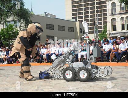 Senior Airman Corey Mcenery, 502nd Civil Engineer Squadron Explosive Ordnance Disposal technician at Joint Base San Antonio-Lackland, demonstrates the uses of a bomb suit and robot as part of bomb disposal procedures during Air Force at the Alamo events in conjunction with Fiesta San Antonio April 20. The suit weighs about 80 pounds and protects Airmen from explosives at an arm’s length, or roughly 3 feet. The robot is used to keep Airmen safe at a greater distance and can be used to inspect and remove a suspicious package.   Melissa Peterson/released) Stock Photo