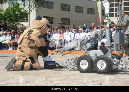 Senior Airman Corey Mcenery, 502nd Civil Engineer Squadron Explosive Ordnance Disposal technician at Joint Base San Antonio-Lackland, demonstrates the uses of a bomb suit and robot as part of bomb disposal procedures during Air Force at the Alamo events in conjunction with Fiesta San Antonio April 20. The suit weighs about 80 pounds and protects Airmen from explosives at an arm’s length, or roughly 3 feet. The robot is used to keep Airmen safe at a greater distance and can be used to inspect and remove a suspicious package.  Melissa Peterson/released) Stock Photo