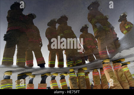 U.S. Air Force Academy cadets are seen reflected in a pool of standing water from fire hoses as they visit Airmen assigned to the 673rd Civil Engineer Squadron on Joint Base Elmendorf-Richardson, Alaska, Wednesday, May 20, 2015, to learn about firefighting and rescue techniques under demanding conditions. The cadets are studying civil engineering at the Air Force Academy, and took advantage of this opportunity to learn from Airmen and noncommissioned officers with experience in their field of choice. Justin Connaher) Stock Photo