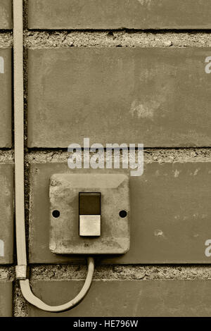 Outdoor electric equipment control industrial button switch wire cable closeup, old aged weathered grungy brick wall background texture pattern, large Stock Photo