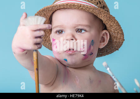 Baby Girl with a Hat Covered in Paint Stock Photo