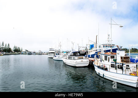 Boats for pleasure and commercial fishing work sit side by side in the harbour at Lakes Entrance in Victoria, Australia. Stock Photo