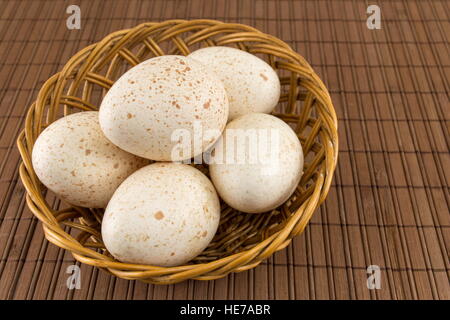 Bunch of raw turkey eggs in a wicker bowl Stock Photo