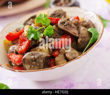 Fried chicken liver with apples and paprika in bowl Stock Photo