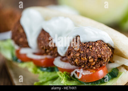 Wooden table with a fresh made Falafel Sandwich (selective focus; close-up shot) Stock Photo