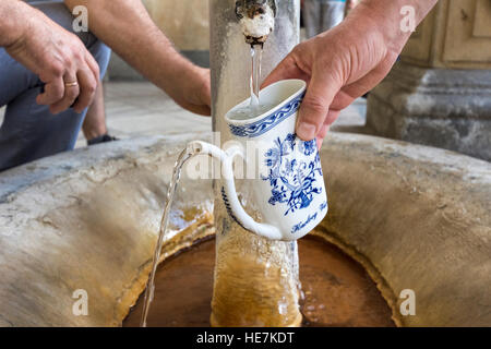 Filling a cup with thermal spring water in Karlovy Vary, Czech Republic Stock Photo