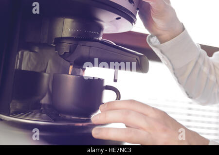 Man is making morning coffee in coffee machine. Retro photo effects Stock Photo