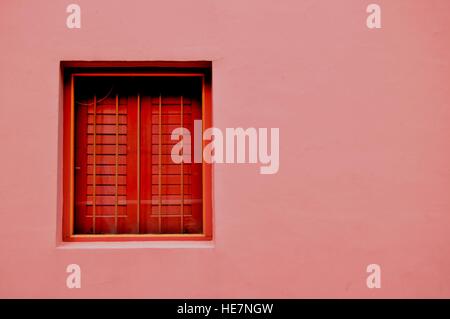 Pink wall with red window in Emerald Hill, Singapore Stock Photo