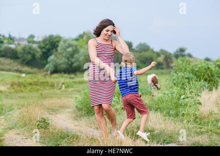 Pregnant woman walking countryside with her son. Happy mother and her son Stock Photo