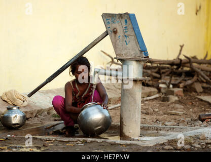 Indian village girl smiling and plumbing borewell for water Stock Photo