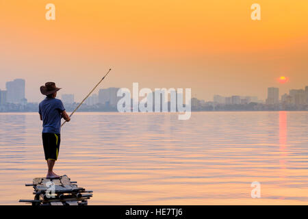 A man fishing on the West Lake in Hanoi, Vietnam Stock Photo