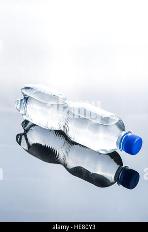 Small plastic water bottle on mirror table. Stock Photo