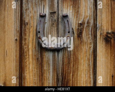 Horseshoe and two horseshoe nails on wooden plank Stock Photo - Alamy
