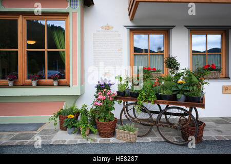 An old wooden wagon decorated with flowers. Hotel Gut Steinbach. Reit im Winkl. Upper Bavaria. Germany. Stock Photo