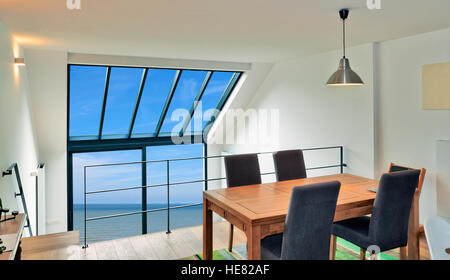 Dining table in modern duplex with large windows and sea Stock Photo