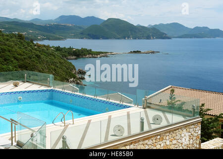 Sivota, GREECE, May 09, 2013: Landscape with swimming pool, the mountains and the blue sea in Greece. Stock Photo