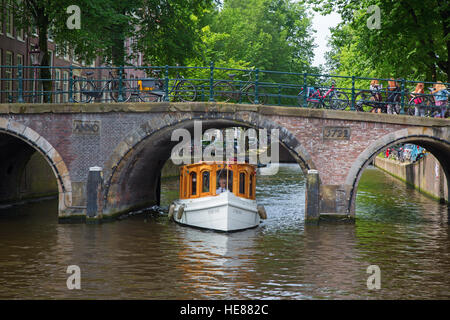 AMSTERDAM - JULY 10: Canals of the Amsterdam city on July 10, 2016 in Amsterdam, Netherlands. The historical canals of the city surrounded by traditio Stock Photo