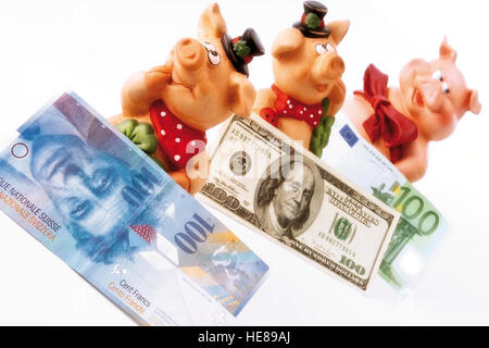 Pigs as a symbol of good luck with various currency banknotes Stock Photo