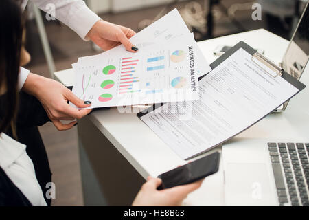 Business team analyzing income graphs with modern laptop computers. Close up analysis and strategy concept. Stock Photo