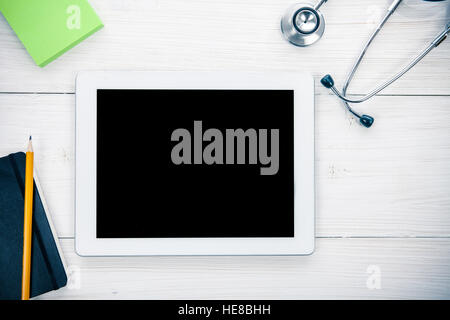 Tablet Computer With Blue Stethoscope on Wooden Background Stock Photo