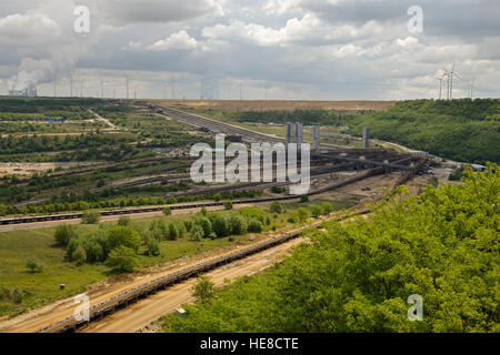 Parts of Garzweiler surface mine, shot from Jackerath viewpoint, with power plants and wind turbines behind. Stock Photo
